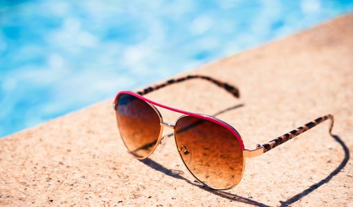 Brown funky sun glasses near swimming pool.